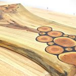 DIY face grain cutting board made from walnut with cherry wood inlays and epoxy details.
