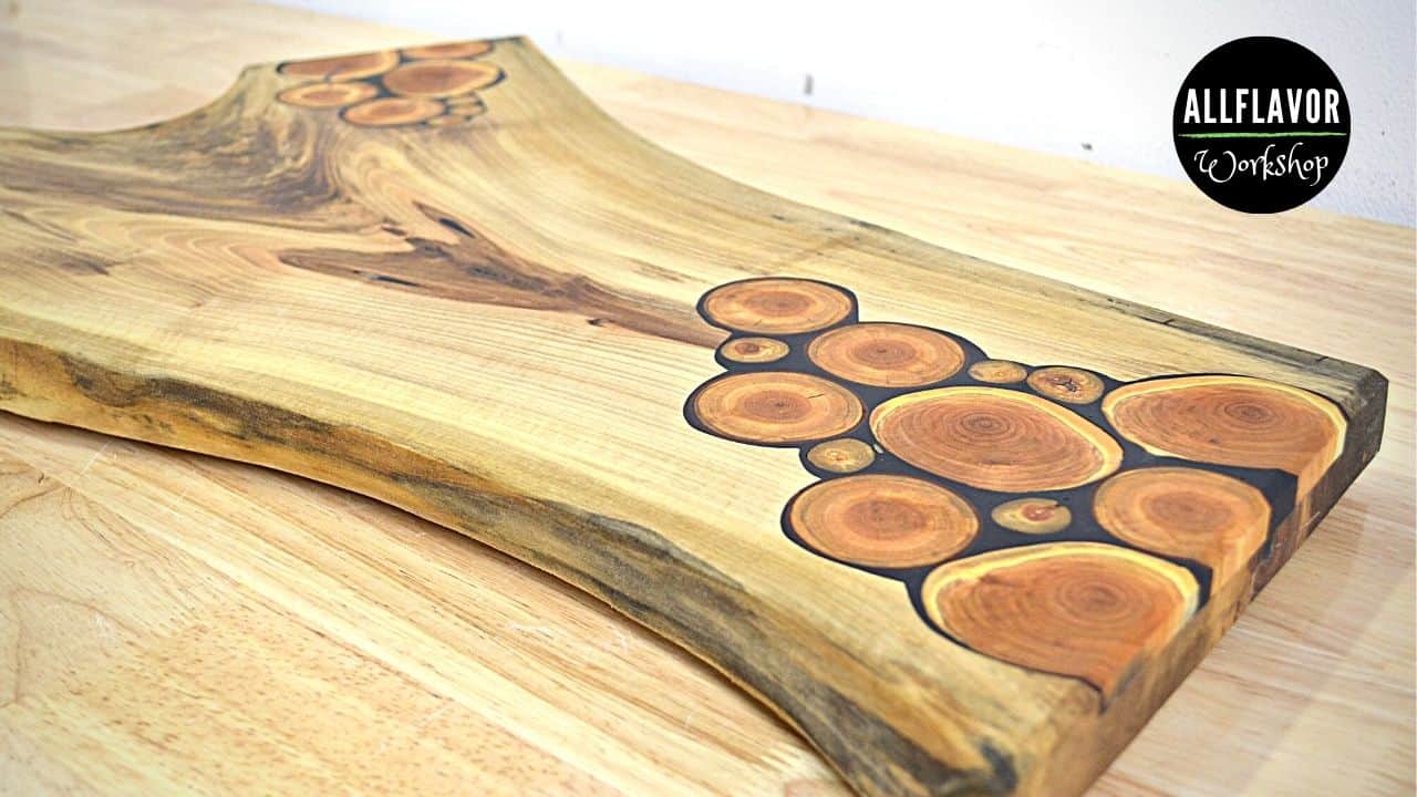 DIY face grain cutting board made from walnut with cherry wood inlays and epoxy details.