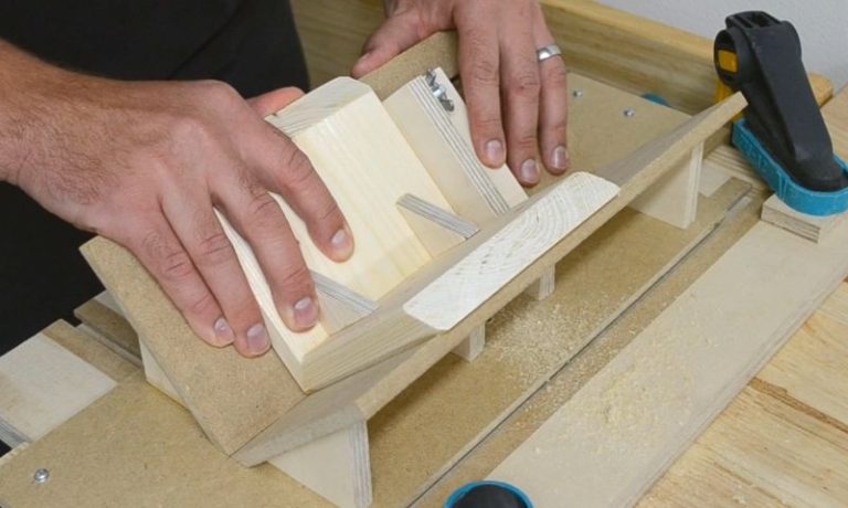Spline jig mounted to a router table, used for reinforcing miter joints.