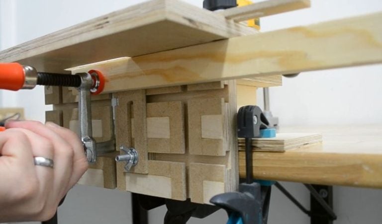 Router mortising jig clamped securely to a workbench, ready for use with a plunge router.