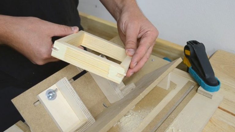 Spline jig attached to router table with a panel clamped at a 45-degree angle