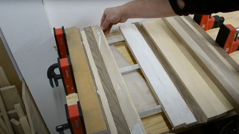 Applying wood glue evenly along the edges of walnut, ash, and beech strips.