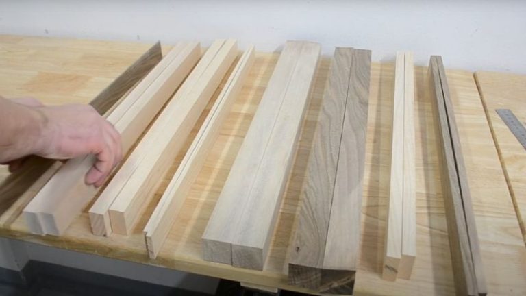 Arranging walnut, ash, and beech wood strips into a final cutting board pattern.
