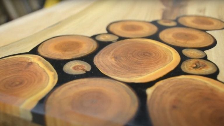 Face grain walnut cutting board with live edge and cherry wood inlays photographed in natural light.
