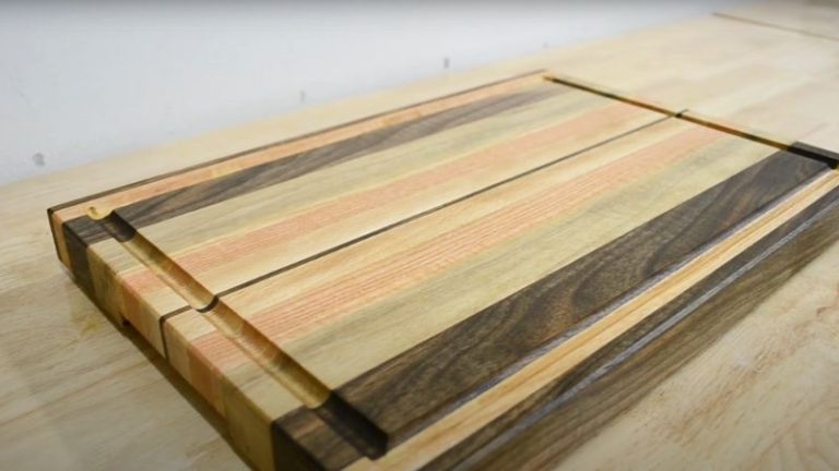 Finished oiled and waxed edge grain cutting board with juice groove and routed handles.