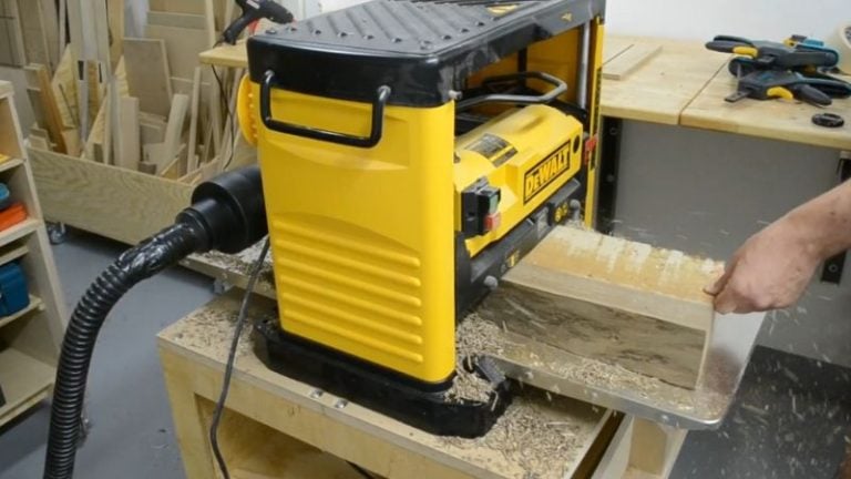 Planing a walnut slab attached to a plywood base to remove twist and flatten both sides.