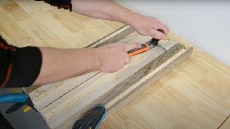 Removing dried glue from a cutting board panel using a wood scraper.