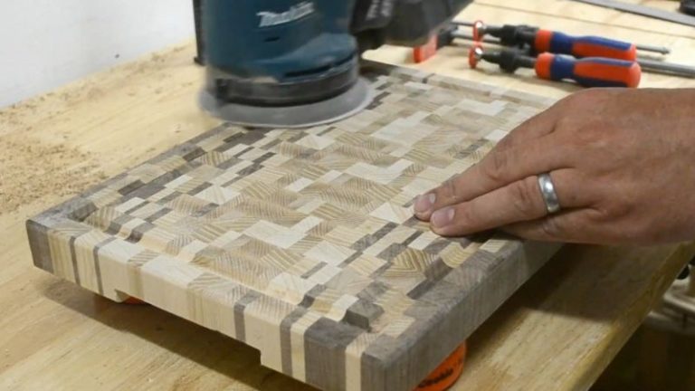 Sanding an ombré end grain cutting board with an orbital sander.