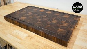 DIY walnut end grain cutting board with juice groove, beveled edges, and rubber feet ready for use.