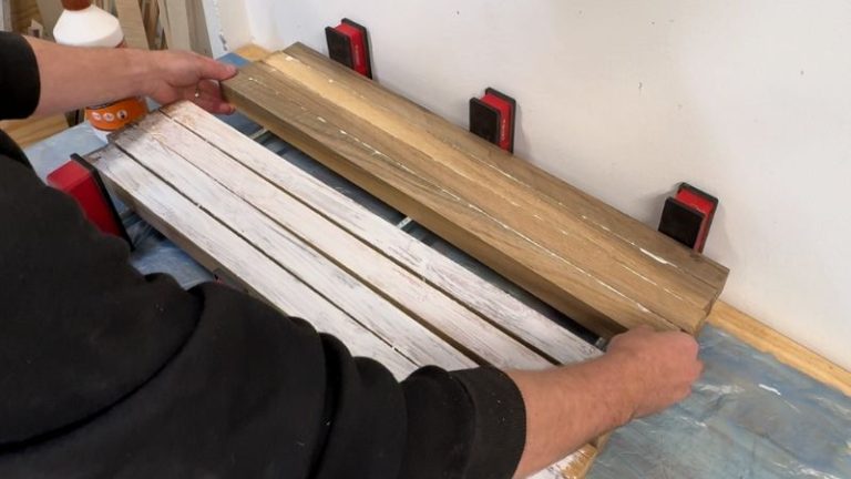 Wood glue being spread along the edge of walnut strips with a silicone brush before clamping.