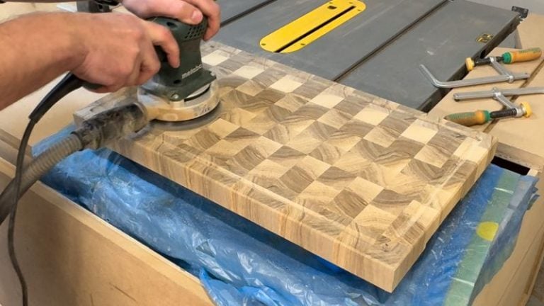 End grain cutting board being sanded on bench cookies with a random orbital sander.