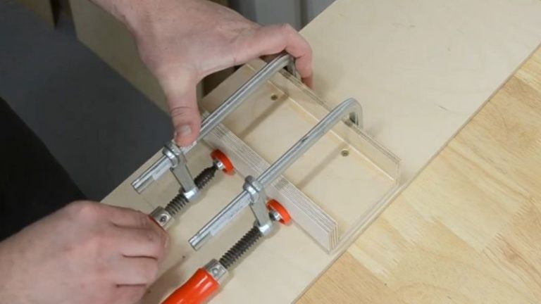 Side stands clamped into the rabbets on the push block base while the glue dries.