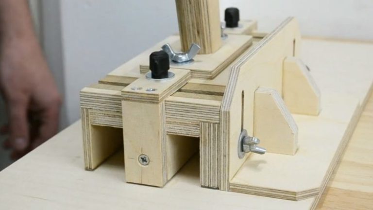 Fully assembled DIY table saw push block with handle, center leg, side stand, and rubber pads on a table saw.