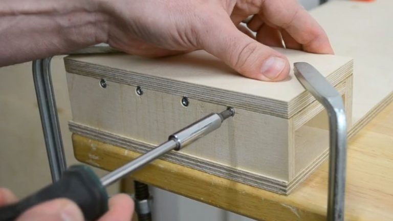 Securing the side stands to the push block base with screws from the sides.