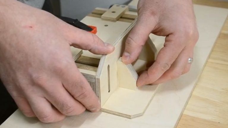 Gluing the vertical side stand to the horizontal base and reinforcing it with two support blocks.