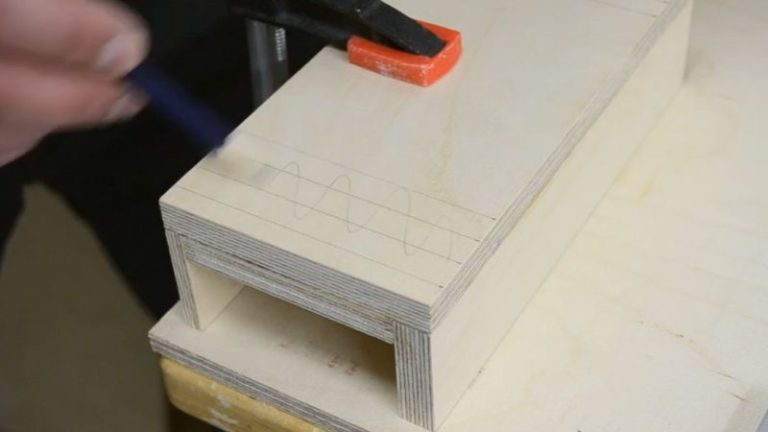 Marking the position of two T-tracks on top of the DIY table saw push block base.