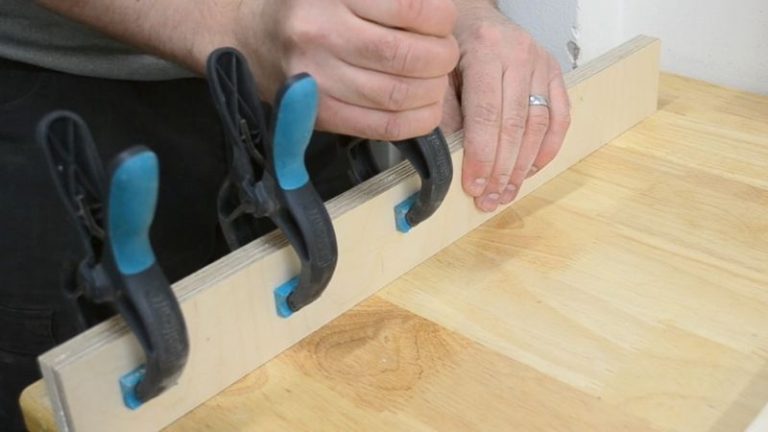 Plywood fence pieces glued and clamped together to form thicker fences for the picture frame jig.