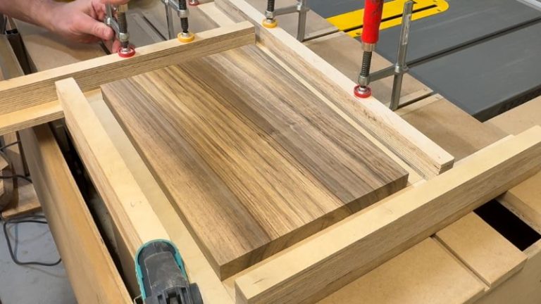 Walnut cutting board clamped securely in a juice groove jig before routing the groove.