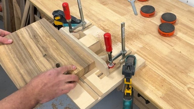 Beveling the edges of a walnut cutting board on a router table using a 45-degree bevel bit.