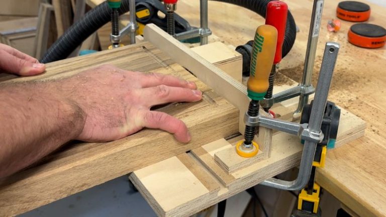 Routing a side handle into a walnut cutting board on a router table using a cove bit.