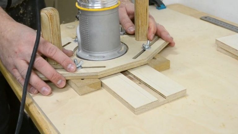 Plywood base with pencil lines marked and a router multipurpose jig set up to cut the T-track dadoes.