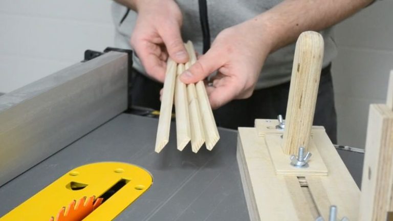 Several uniform thin strips lying next to the table saw thin strip jig after cutting.