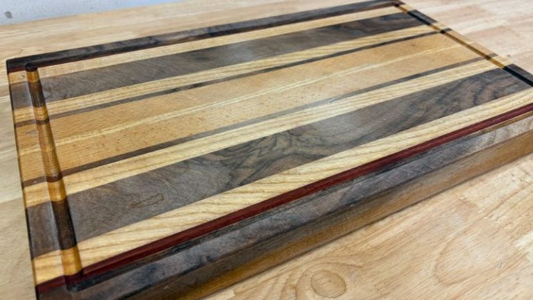 Full view of a heavily used edge grain cutting board before refinishing, showing surface wear and juice groove damage.
