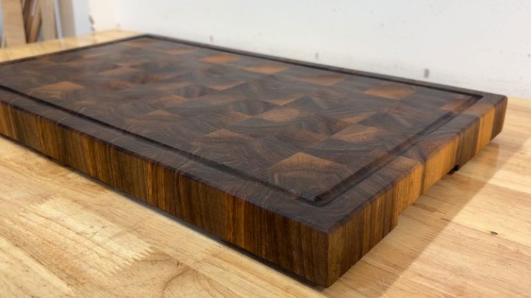 Cutting board with rubber feet slightly elevated on a countertop for better grip and easier lifting.