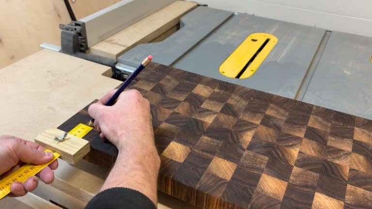 Using a ruler marking gauge to set an exact offset from the cutting board edge for rubber foot placement.