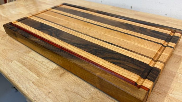 Restored edge grain cutting board close-up after oiling and waxing, showing rich walnut contrast with lighter woods.