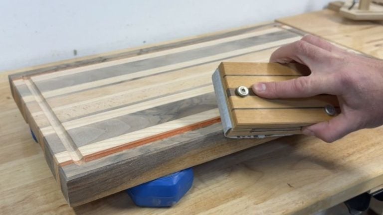 Sanding the edges of a cutting board after with a sanding block.