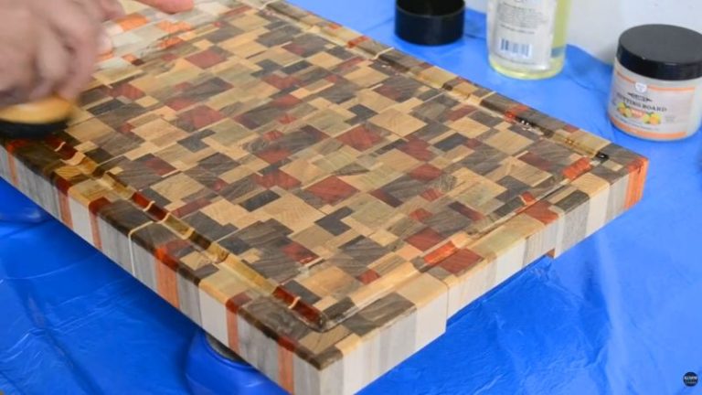 Applying Clark’s cutting board oil to a wooden cutting board with a cloth to pop grain and protect the surface.