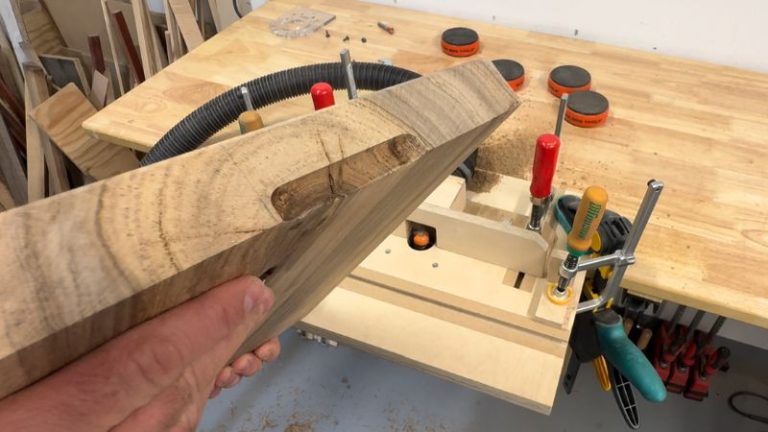 Finished underside finger grip handle routed with a cove bit on a cutting board, centered on the side and sized for rubber feet.