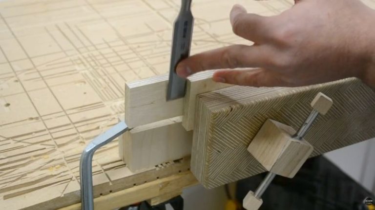 Removing dried glue from laminated plywood frame parts with a chisel before assembly.