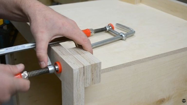 Gluing plywood support blocks to the bottom of a DIY planer stand for caster installation.