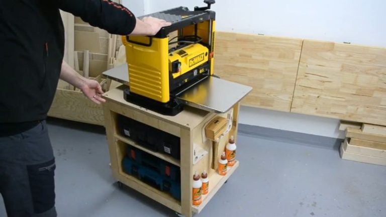 Finished DIY planer stand with storage shelves, racks, and mounted accessories in the workshop