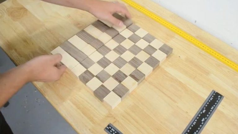 Rotating alternating strips of beech and walnut blocks to form a checkerboard pattern before final glue-up.