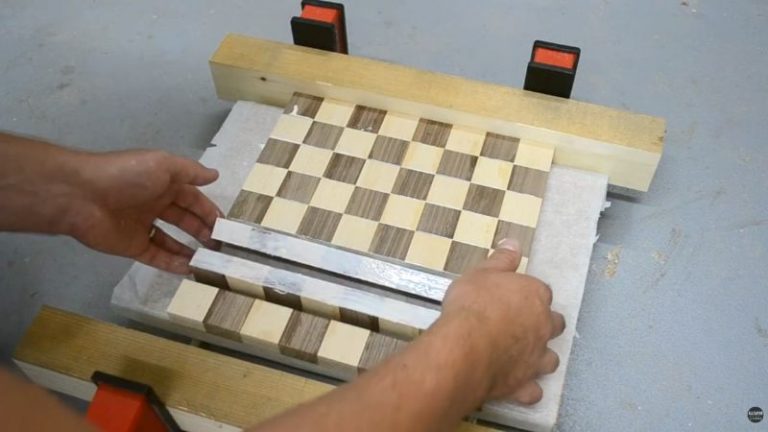 Second glue-up of chessboard strips with corners aligned carefully so the squares meet cleanly before clamping.