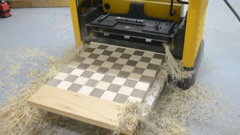 Running a chessboard panel through a thickness planer with light passes to flatten and level the surface.