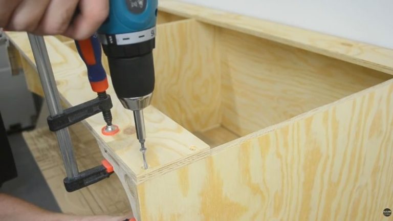 Attaching the back upper support strip to the lumber cart frame while leaving the middle divider loose for final spacing adjustments.