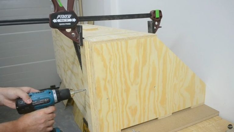 DIY lumber storage cart flipped upside down with two reinforcement strips added on the bottom to support caster mounting.