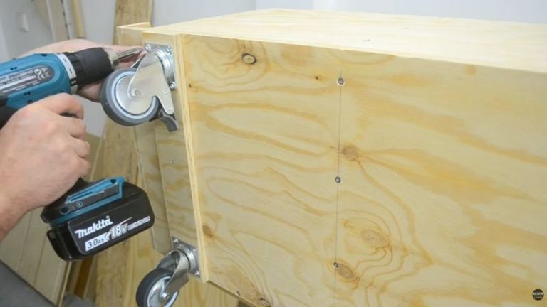 Installing heavy-duty locking casters on the front of a lumber storage cart for stability and easy movement around the workshop.