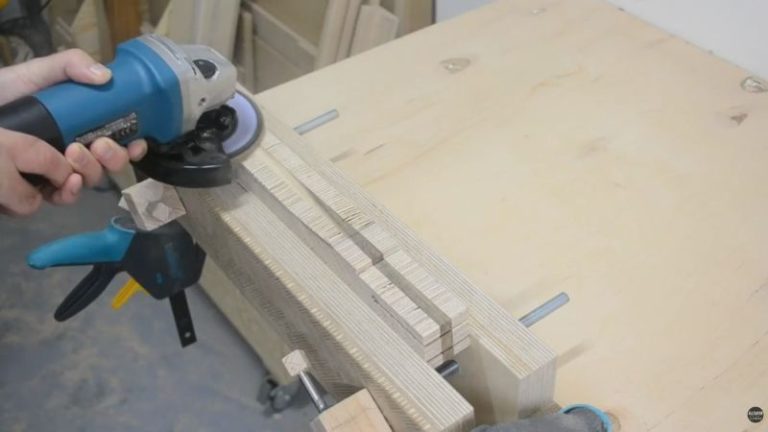 Rough shaping a wooden mallet handle using a grinder to remove excess material before sanding to final shape.