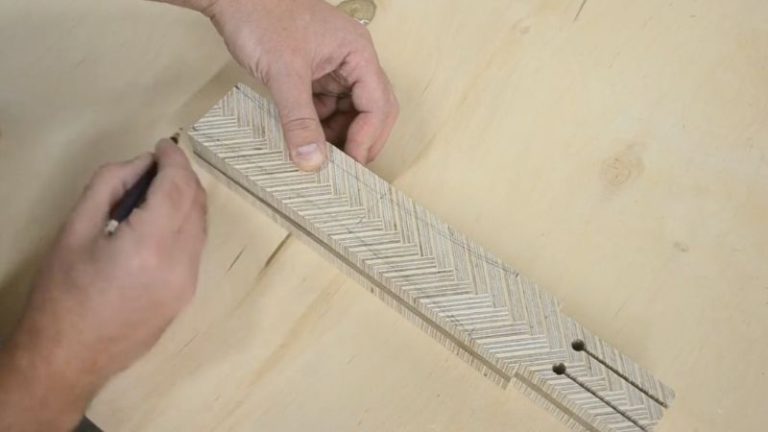 Marking guide lines on a laminated wooden mallet handle blank to shape a comfortable grip.