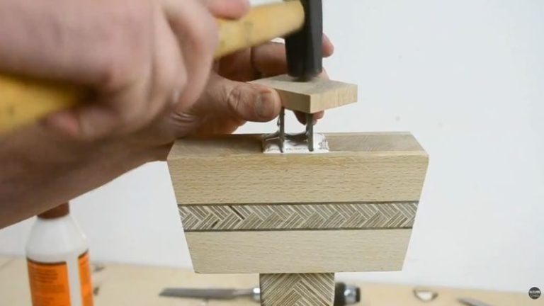 Installing the wooden mallet handle into the head with glue and driving wedges into the slots to lock the handle in place.