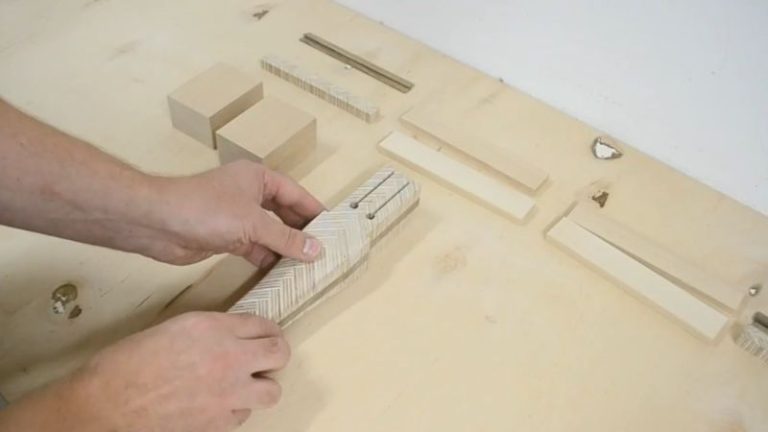 Mallet head parts laid out after cutting, including two beech head blocks, beech strips, walnut inlays, and a patterned plywood strip.