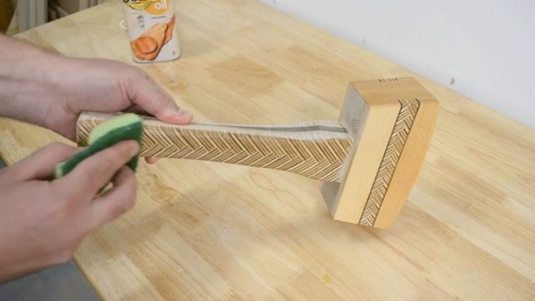 Applying Belinka oil to a wooden mallet to protect the wood and bring out contrast between beech, walnut, and patterned plywood.