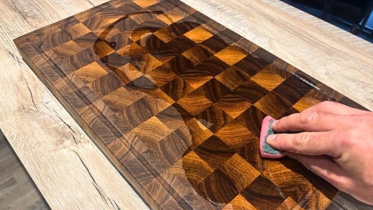 Spreading oil evenly across a walnut cutting board as part of regular cutting board care.