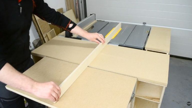 Tabletop and folding outfeed table for a DIY mobile table saw workbench made from plywood and MDF, aligned with the table saw.