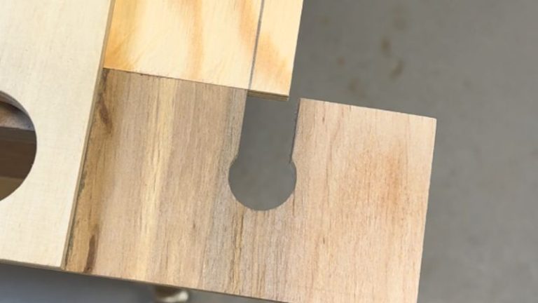 Router rabbet jig aligned with a pencil rabbet line on a plywood workpiece.